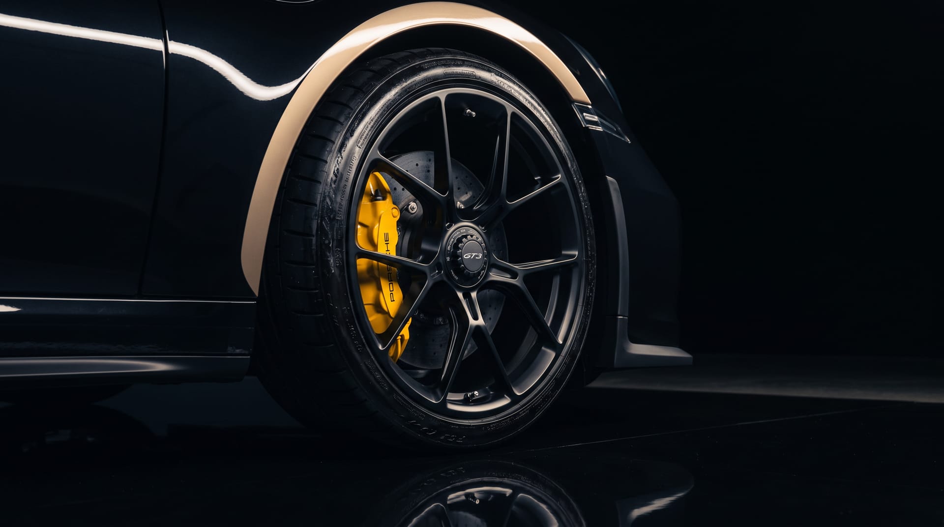 Polished alloy wheel with visible brake caliper on a performance car in the GT Exclusive studio